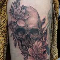 Explore our realistic skull and flowers tattoo by Tiny, combining intricate detail with symbolic beauty at The Wolves Den. Realistic skull and flowers tattoo by Tiny at The Wolves Den Pakenham.