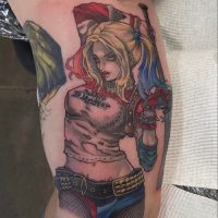 Explore our neo-traditional Harley Quinn tattoo by Tiny, blending comic-inspired art with vibrant colors at The Wolves Den. Neo-traditional Harley Quinn tattoo by Tiny at The Wolves Den Pakenham.