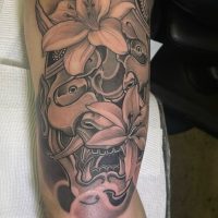 Explore our realistic Japanese mask tattoo by Tiny, showcasing intricate artistry and cultural symbolism at The Wolves Den. Realistic Japanese mask tattoo by Tiny at The Wolves Den Pakenham.